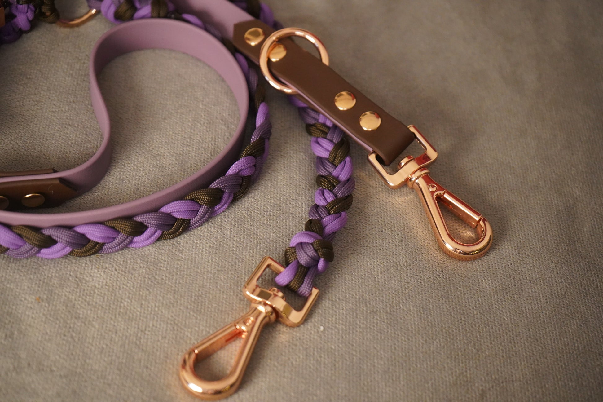 Detailaufnahme der Biothane® + Paracord Hundeleine – handgefertigt in Lila und Braun mit glänzenden Roségold-Beschlägen von Pama.